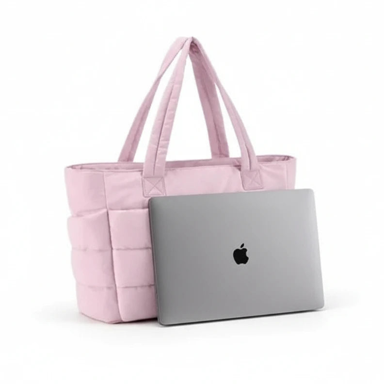 Pink tote bag with a white pouch and an Apple laptop on a white background. 