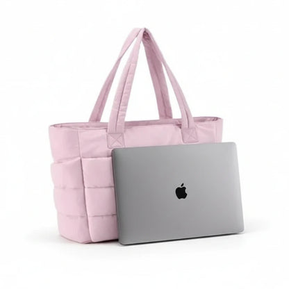 Pink tote bag with a white pouch and an Apple laptop on a white background. 