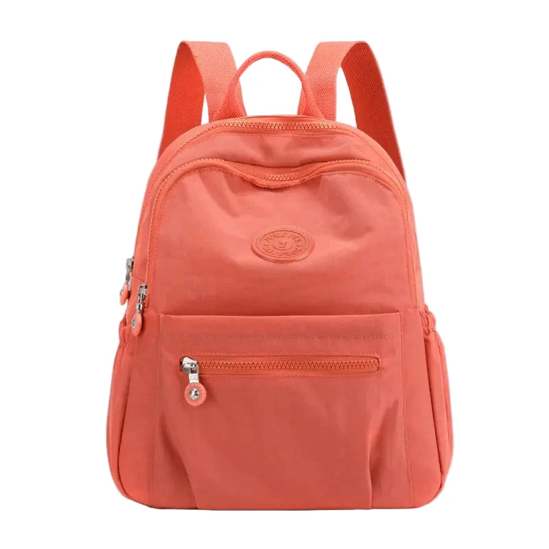 Coral backpack with a visible brand logo on a white background