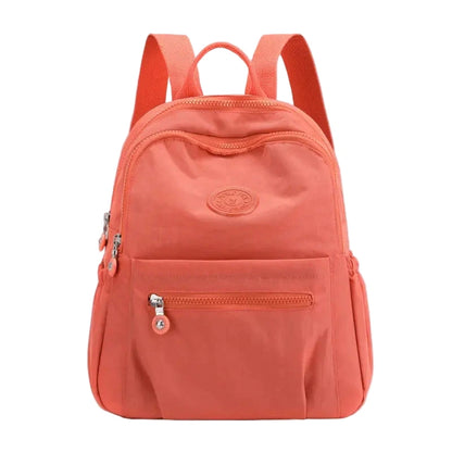 Coral backpack with a visible brand logo on a white background