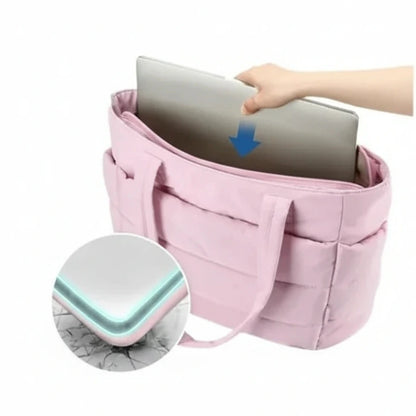 Pink laptop bag with anti-collision soft lining feature, showing a hand placing a laptop inside.