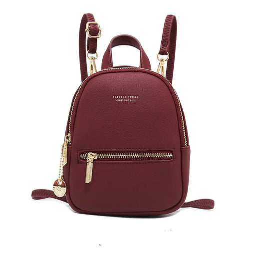 Maroon backpack with gold zippers on a white background