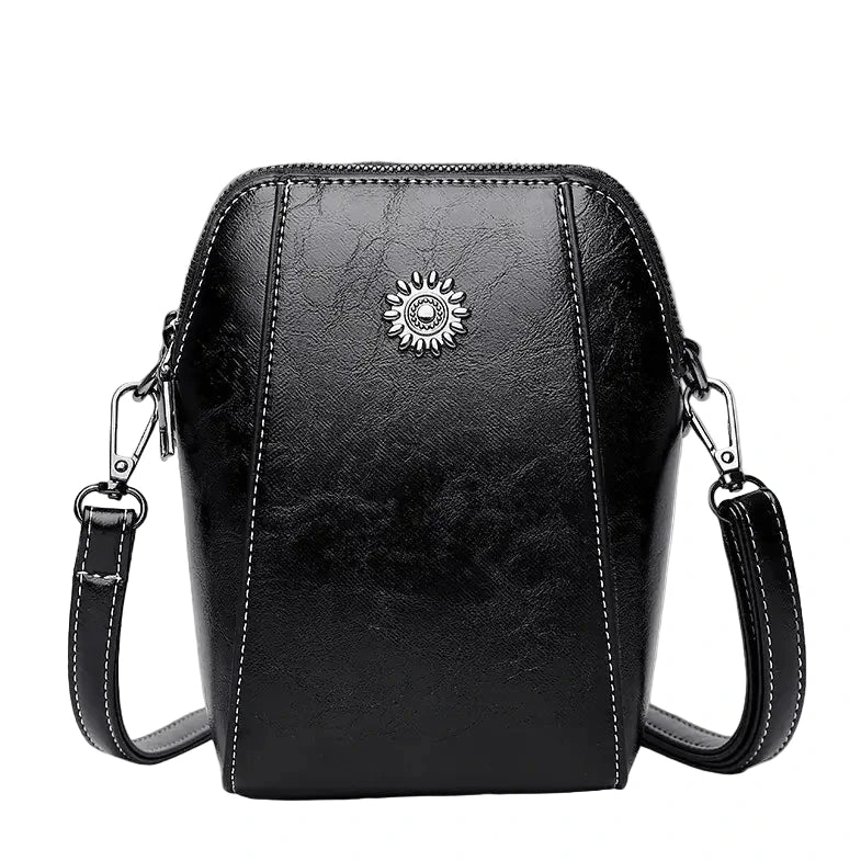 Black leather crossbody bag with a sun emblem on a white background